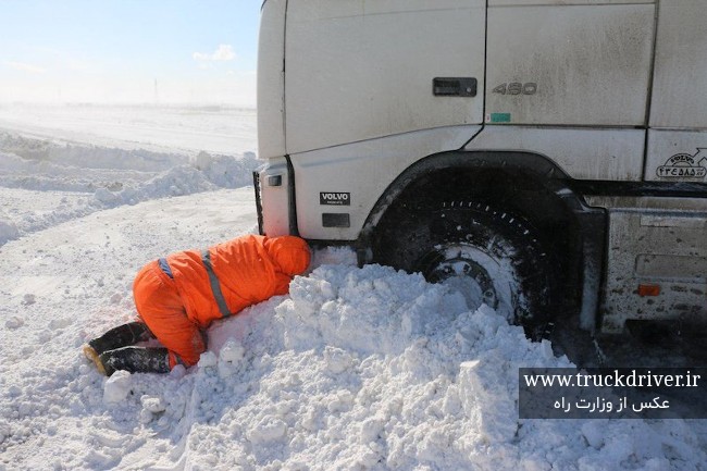 راهدار در حال کمک به کامیون گیر کرده در برف